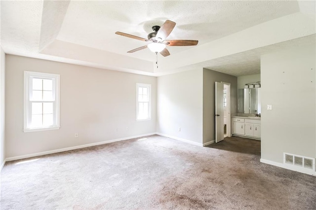 263 Austin Rd, Stockbridge, GA 30281 - unfurnished room with visible vents, dark carpet, baseboards, a raised ceiling, and a ceiling fan