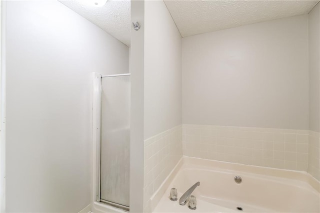263 Austin Rd, Stockbridge, GA 30281 - full bathroom featuring a garden tub, a textured ceiling, and a stall shower