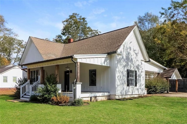 rear view of property with a lawn and a porch