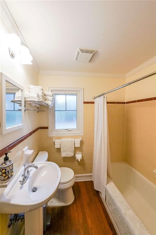 2889 Mount Olive Dr, Decatur, GA 30033 - full bath featuring toilet, ornamental molding, shower / bath combo, wood finished floors, and a sink