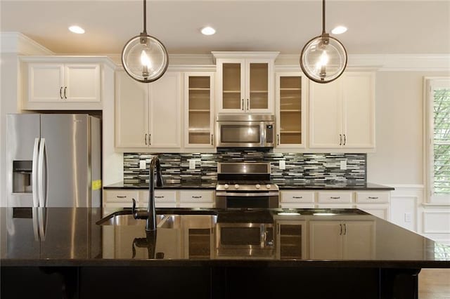 kitchen featuring pendant lighting, stainless steel appliances, sink, and a center island with sink