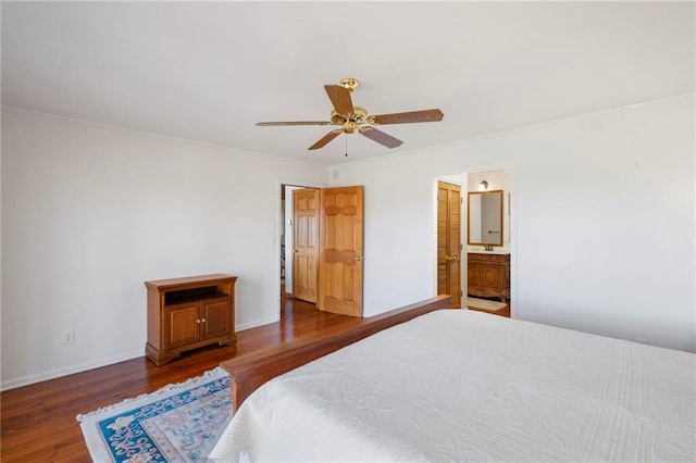 bedroom featuring baseboards, ensuite bathroom, dark wood-type flooring, and ornamental molding