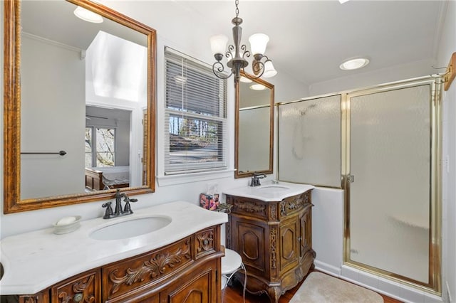 full bath featuring a stall shower, two vanities, and a sink