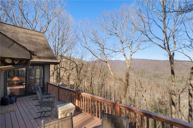 deck featuring a mountain view and a wooded view