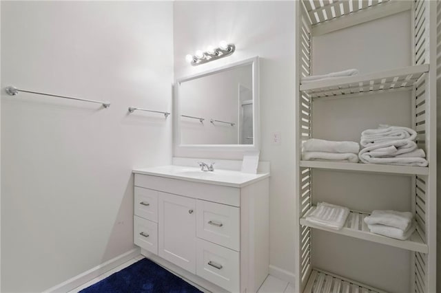 bathroom with a closet, vanity, and baseboards