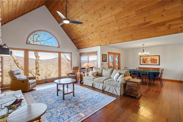 living room with high vaulted ceiling, ceiling fan with notable chandelier, plenty of natural light, and wood finished floors