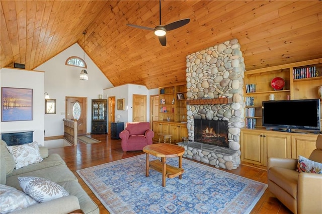 living room featuring light wood finished floors, wood ceiling, built in shelves, and a stone fireplace