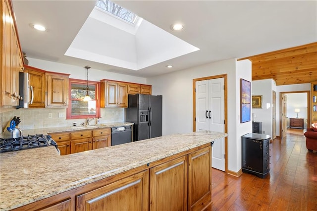 kitchen featuring a skylight, decorative light fixtures, decorative backsplash, wood finished floors, and black appliances