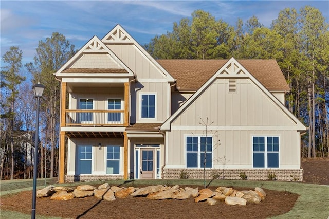 view of front of house with a balcony and a front yard