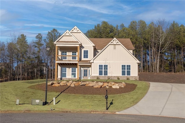 craftsman-style home featuring a balcony and a front yard