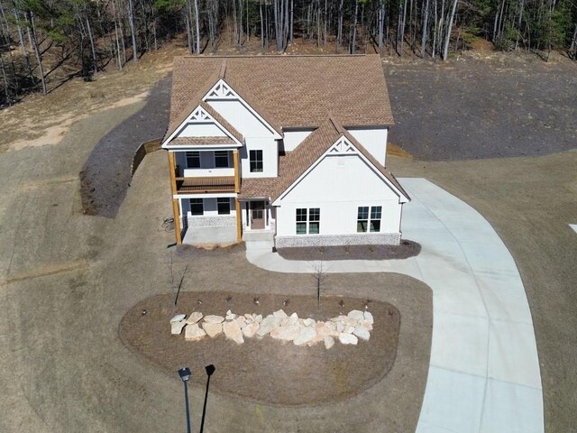 craftsman-style house featuring a balcony and a front lawn