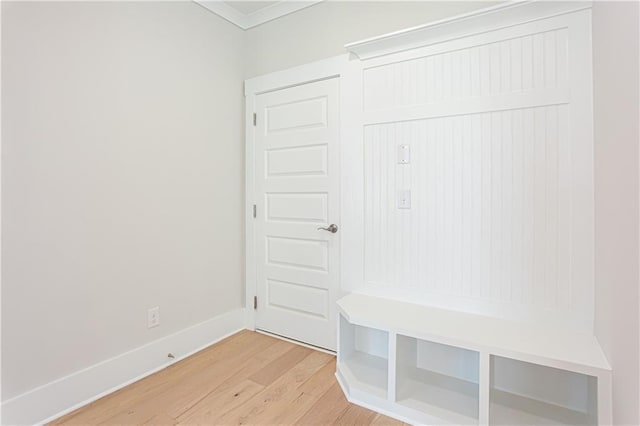 mudroom featuring baseboards, ornamental molding, and light wood finished floors