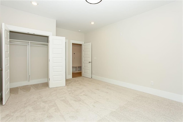 unfurnished bedroom featuring a closet, recessed lighting, baseboards, and carpet