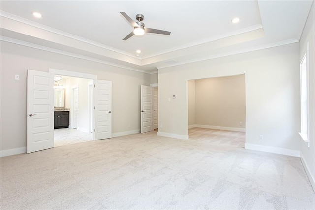 unfurnished bedroom with a tray ceiling, ornamental molding, and light carpet