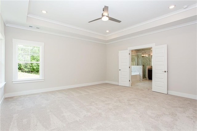 empty room with baseboards, recessed lighting, light carpet, crown molding, and a raised ceiling