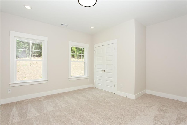 spare room featuring recessed lighting, baseboards, and light colored carpet