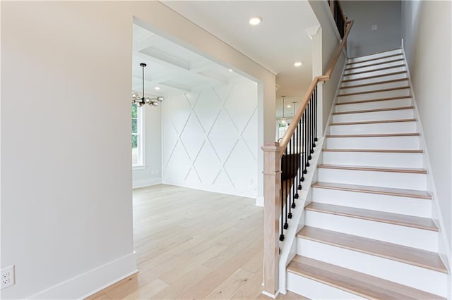 staircase with hardwood / wood-style flooring, coffered ceiling, a notable chandelier, and beamed ceiling