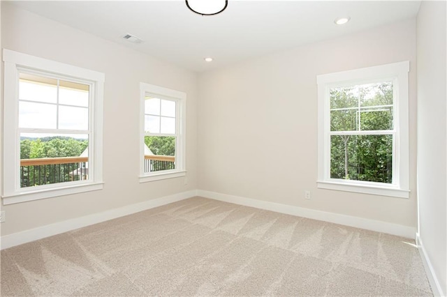 spare room with recessed lighting, light colored carpet, and baseboards