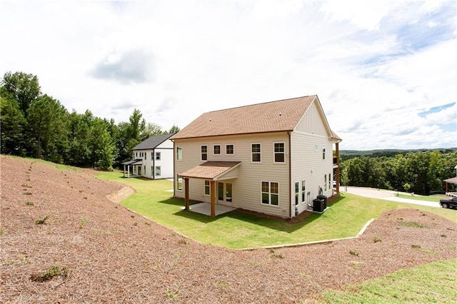 back of house featuring a yard, board and batten siding, central AC, and a patio area