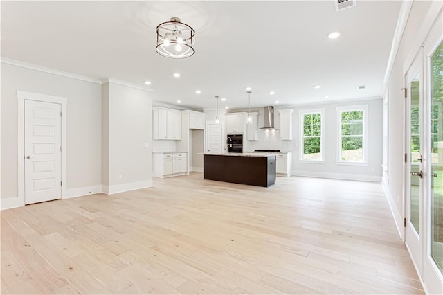 unfurnished living room featuring recessed lighting, baseboards, light wood-style floors, and ornamental molding