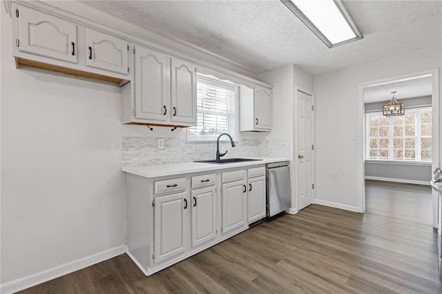 kitchen with plenty of natural light, sink, stainless steel dishwasher, and white cabinets