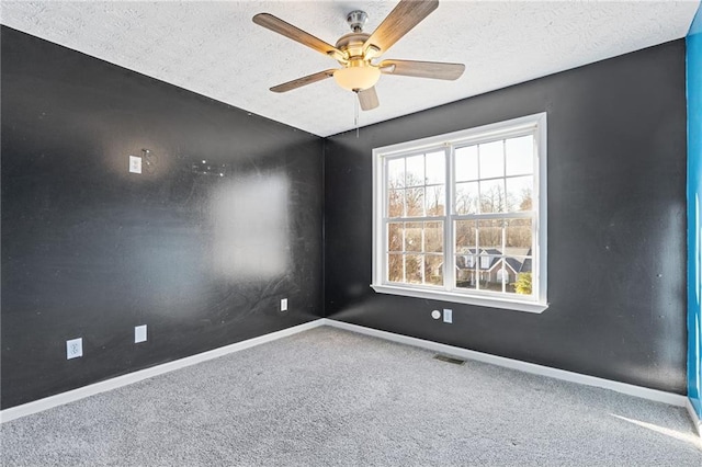 carpeted empty room featuring ceiling fan and a textured ceiling