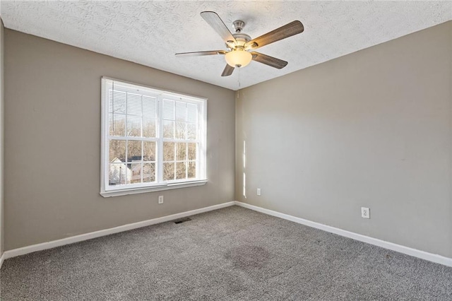 carpeted spare room with a textured ceiling and ceiling fan