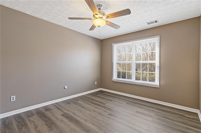 spare room with ceiling fan, dark hardwood / wood-style floors, and a textured ceiling