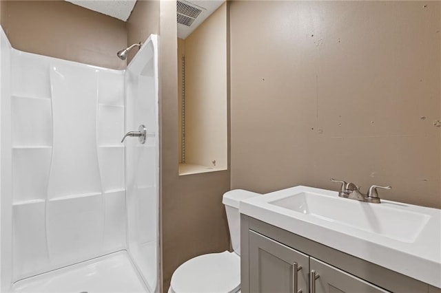 bathroom featuring vanity, toilet, and walk in shower