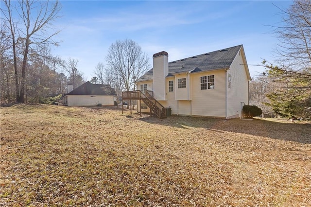 back of property with a deck and a lawn