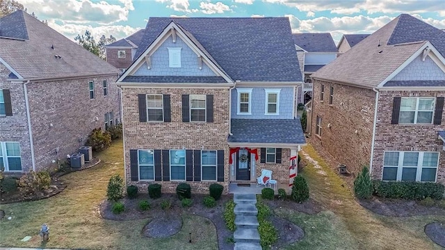 view of front of home with central AC and a front lawn