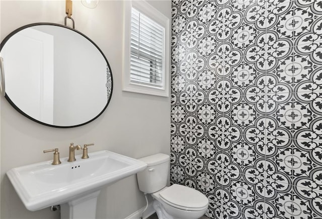 bathroom featuring toilet, tile floors, and sink