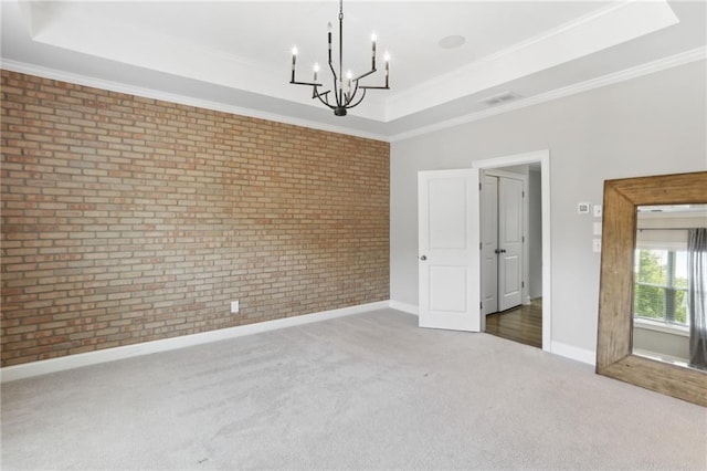 spare room featuring a notable chandelier, dark carpet, a tray ceiling, and crown molding