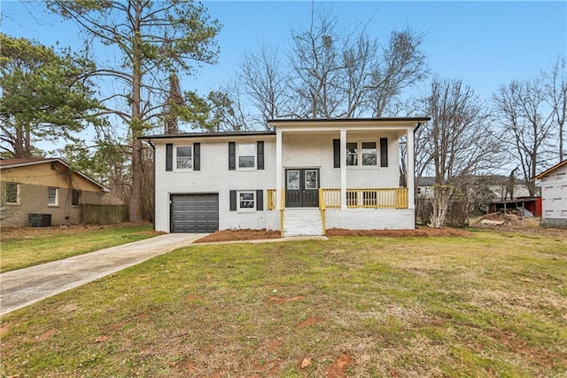 raised ranch featuring a garage, central AC, a front yard, and covered porch