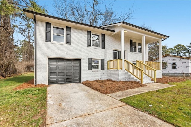 raised ranch featuring a garage and a front yard