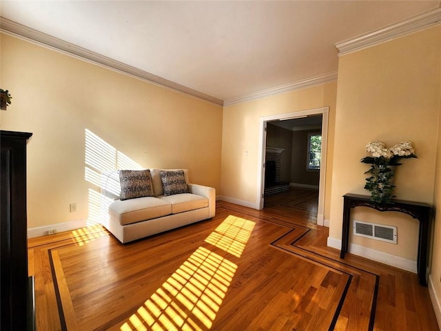 living room featuring crown molding, hardwood / wood-style flooring, and a fireplace