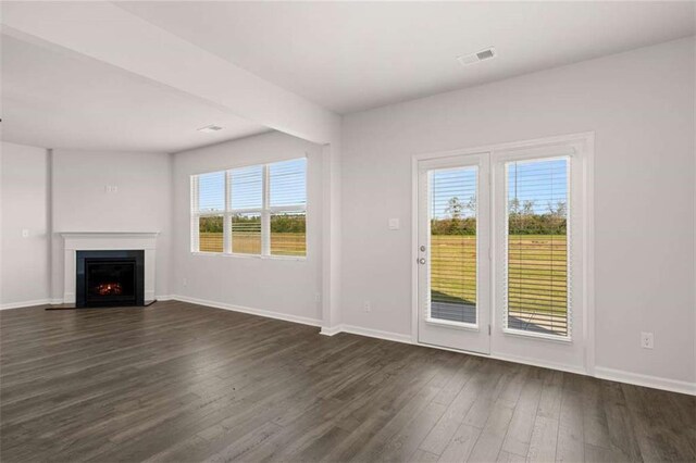 5430 Flat Rock Pt, Stonecrest, GA 30038 - unfurnished living room with dark wood finished floors, plenty of natural light, baseboards, and a lit fireplace