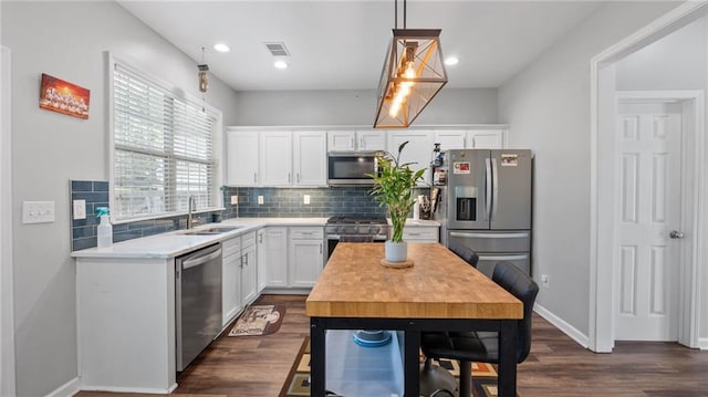 3525 Elder Field Ln, Cumming, GA 30040 - kitchen with stainless steel appliances, a sink, backsplash, white cabinets, and dark wood finished floors