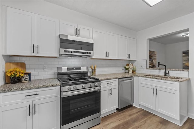 kitchen with decorative backsplash, appliances with stainless steel finishes, white cabinetry, and sink