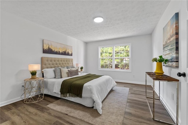 bedroom with a textured ceiling and dark wood-type flooring