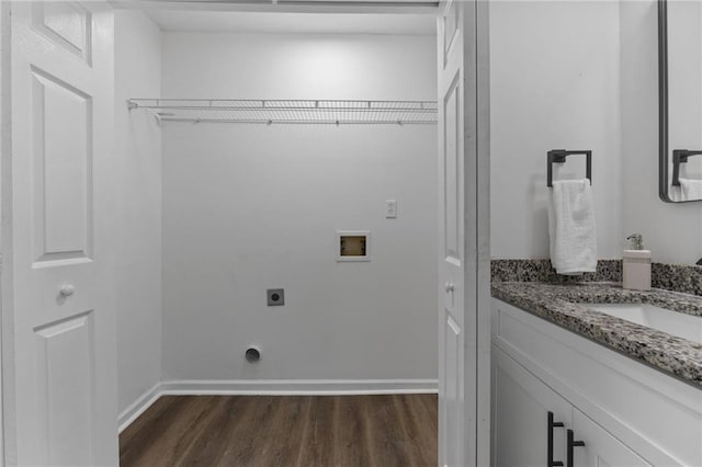 laundry area with hookup for an electric dryer, hookup for a washing machine, dark wood-type flooring, and sink