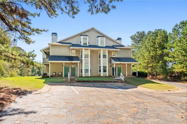 view of front of home with central AC and a front lawn