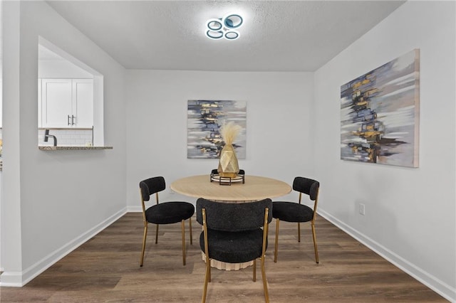 dining room featuring dark hardwood / wood-style flooring and a textured ceiling