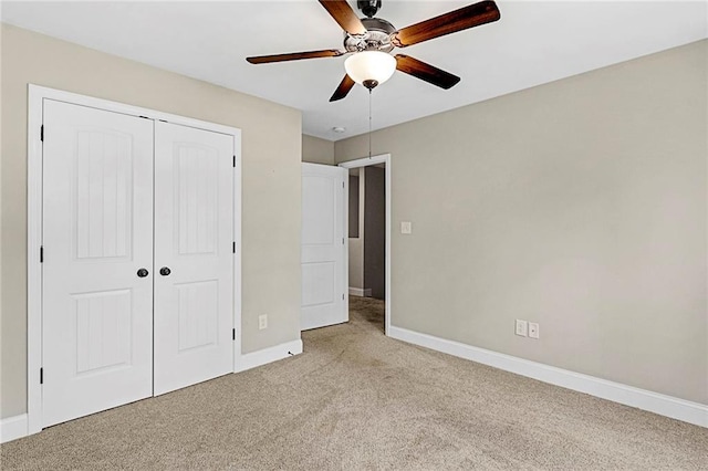 unfurnished bedroom with light carpet, baseboards, a closet, and a ceiling fan