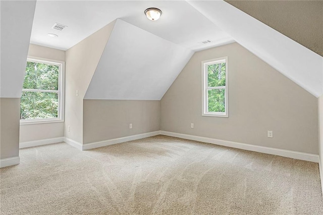 bonus room with healthy amount of natural light, carpet floors, baseboards, and lofted ceiling