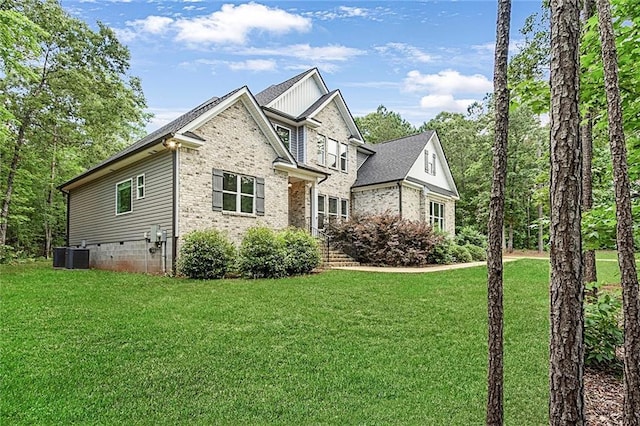 view of home's exterior featuring a lawn, board and batten siding, brick siding, and cooling unit