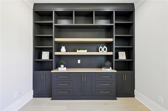bar area featuring baseboards and light wood-style flooring