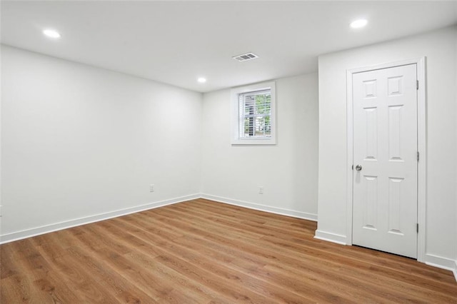 empty room with light wood finished floors, recessed lighting, visible vents, and baseboards