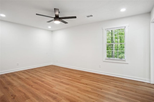 unfurnished room featuring wood finished floors, recessed lighting, and baseboards