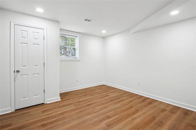 spare room with recessed lighting, visible vents, wood finished floors, and baseboards